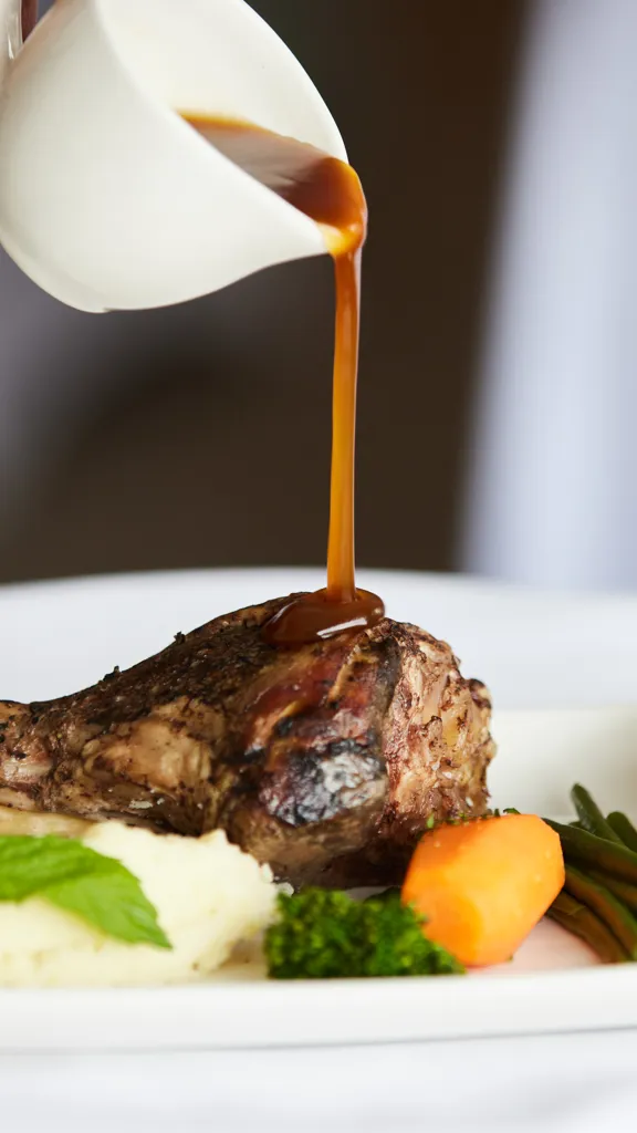 Lamd sunday lunch being poured with gravy